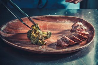 Delicious appetizer with herbs on wooden table close up